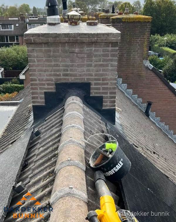Schoorsteen met loodaansluiting en nokvorst op pannendak in Bunnik