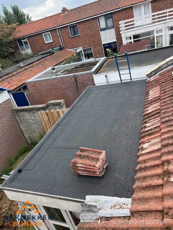 Plat dak aanbouw met bitumen naast schuin pannendak in Bunnik