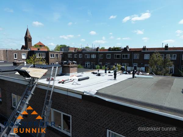 Dakdekkers aan het werk op plat dak in Bunnik