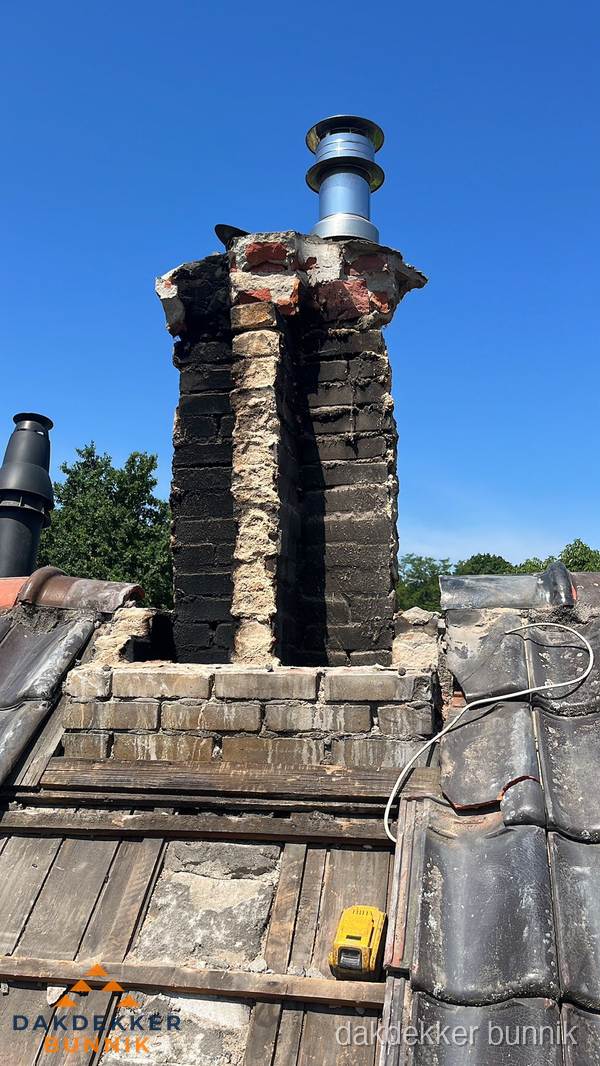 Beschadigde schoorsteen met nieuwe rookgasafvoer op oud dak in Bunnik