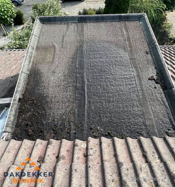 Verouderd plat dak met bitumen en slijtage voor lekkage inspectie in Bunnik