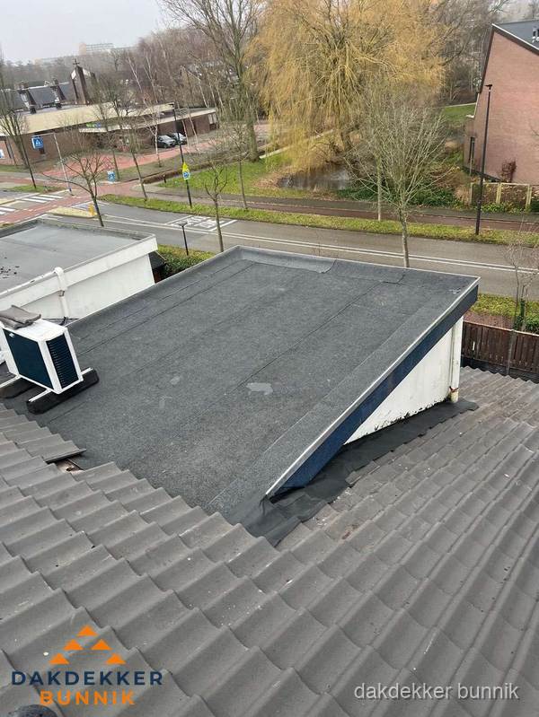 Plat dak met bitumen dakbedekking naast schuin pannendak in Bunnik