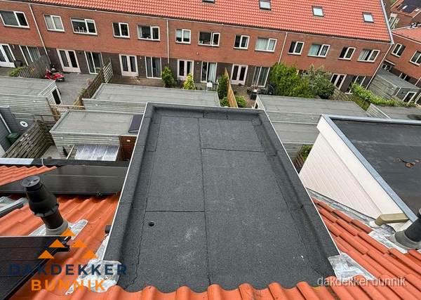 Plat dak met bitumen bedekking naast dakkapel in Bunnik
