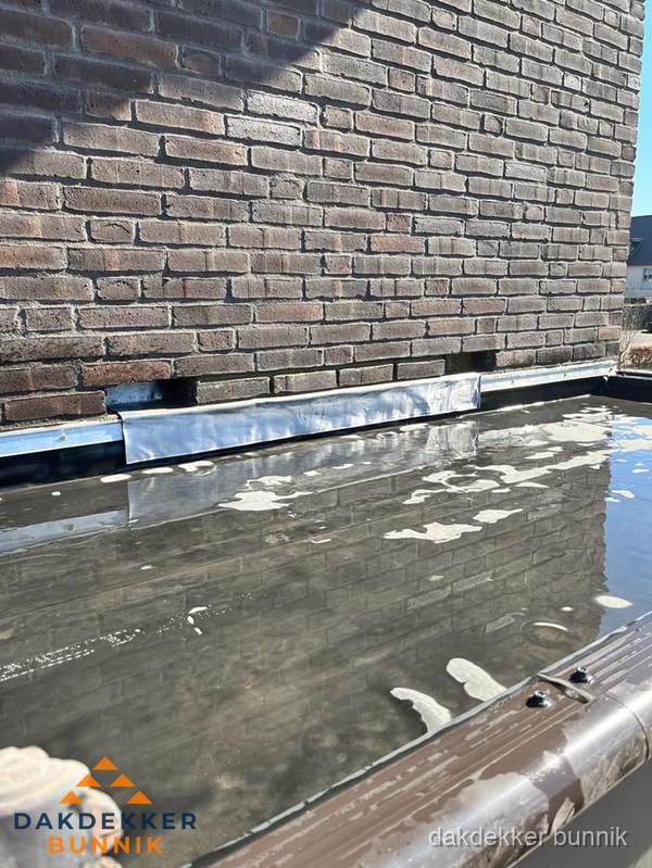 Stilstaand water op plat dak door slechte afwatering in Bunnik Stilstaand water op plat dak door slechte afwatering in Bunnik