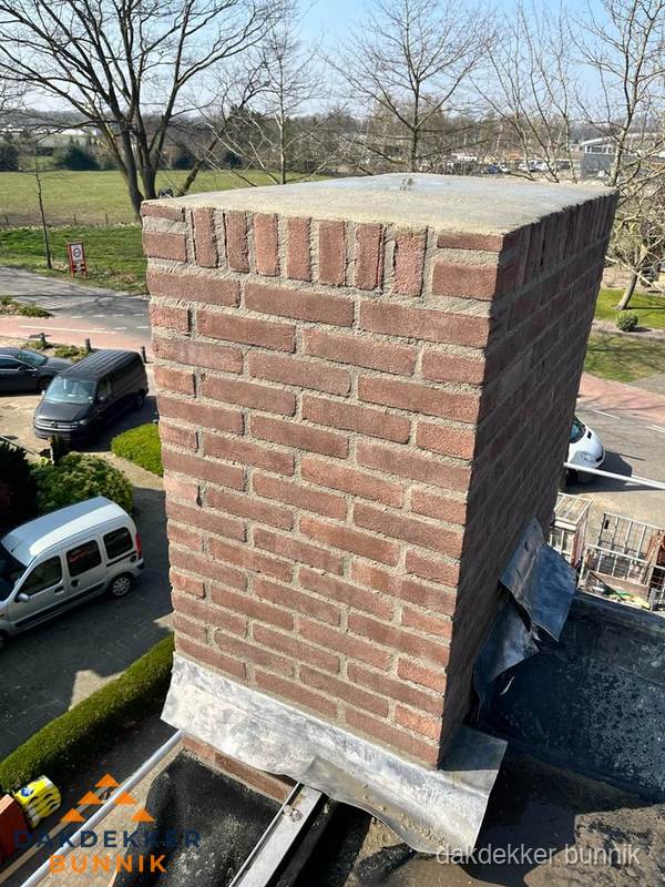 Gemetselde schoorsteen met loodaansluiting op dak in Bunnik Gemetselde schoorsteen met loodaansluiting op dak in Bunnik