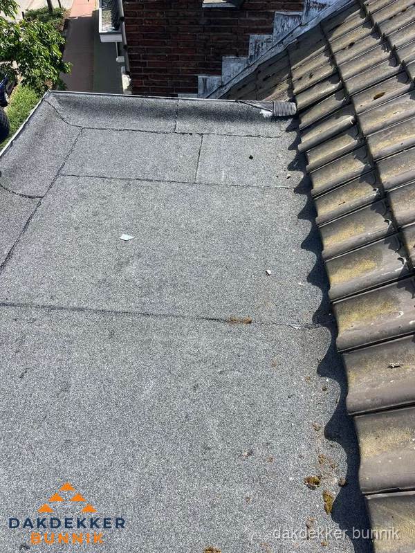 Plat dak met bitumen naast schuin pannendak in Bunnik